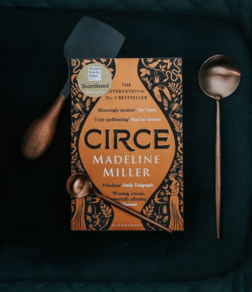Madeline Miller's Circe book on dark green background with copper cutlery