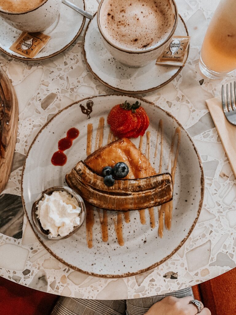 `close up of the baguette French toast, caramel, rum banana, fresh berries, berry coulis